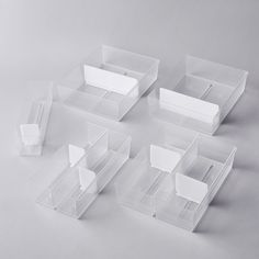 four clear plastic boxes with dividers on each side and an open one in the middle