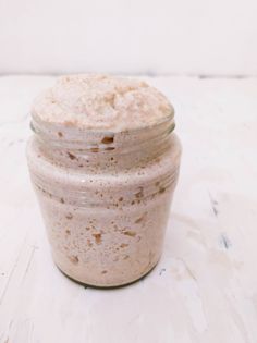 a glass jar filled with food sitting on top of a white table