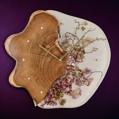 a plate with flowers on it sitting on a purple tablecloth next to a wooden spoon