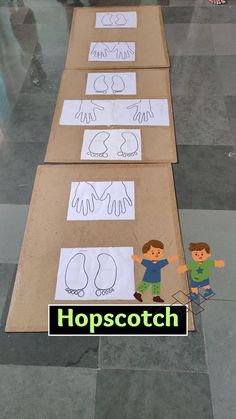 three cardboard boxes with paper cut out of them on top of a tiled floor, and the words hopscotch