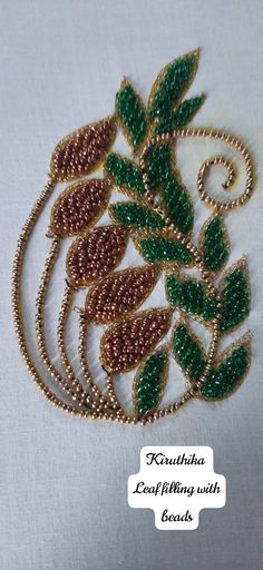 a brooch with beads and leaves on it