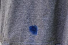 a person wearing a gray shirt with blue spots on it