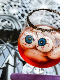 a close up of a wine glass with an evil eyeball decoration on the top