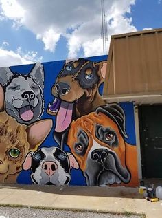 a large painting of dogs and cats on the side of a building