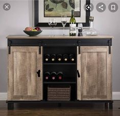 a wooden cabinet with wine glasses and bottles on it in front of a framed painting