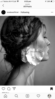 a black and white photo of a woman's head with flowers in her hair