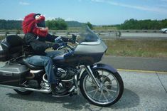 a person riding on the back of a motorcycle with a red wig and face mask