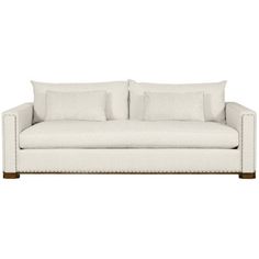 a white couch with four pillows on it's back and one arm facing the camera