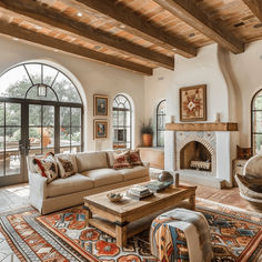 a living room filled with furniture and a fire place in the middle of an open floor plan