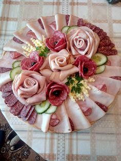 a platter filled with meat and vegetables on top of a checkered table cloth