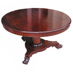 an oval wooden table with ornate carvings on the legs