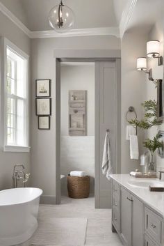 a white bathroom with a tub, sink and toilet next to a window in the corner