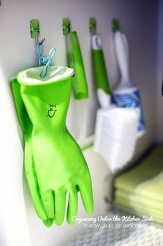 green gloves hanging from hooks on the wall