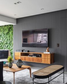 a living room filled with furniture and a flat screen tv mounted on the wall above it