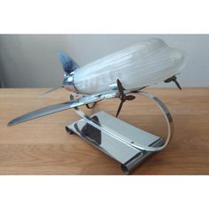 a toy airplane is sitting on top of a stand with two knives attached to it