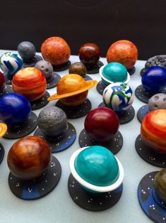 a table topped with lots of different types of balls and planets on top of each other