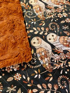 an animal print blanket with two owls on it and one owl in the middle is laying down