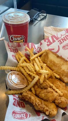 fried chicken and french fries on a table next to a drink