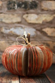 an orange book pumpkin sitting on top of a wooden table with the title, how to make a book pumpkin