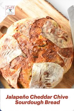 a round bread sitting on top of a wooden cutting board