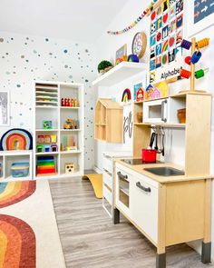 a child's playroom with lots of toys on the shelves and flooring