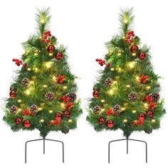 two christmas trees with lights and ornaments on them are shown in front of a white background