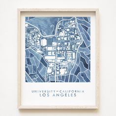 a blue and white map hanging on the wall in front of a wooden frame that says university of california los angeles