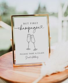 a sign that says, but first champagne please take a glass seat at this wedding