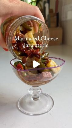 a person is holding a glass bowl with food in it and the words, marinated cheese jarette