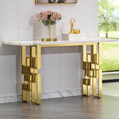 a white marble table with gold accents and flowers in vases on the top shelf