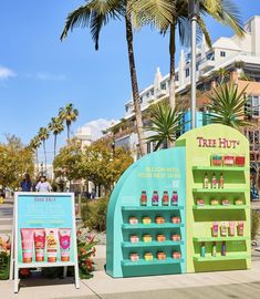 there is a display in front of the store on the side of the street and palm trees