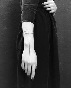 black and white photograph of a woman's hand with a tattoo on her wrist