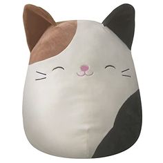 a white and black cat pillow with its eyes closed