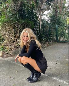 a woman kneeling down on the ground with her legs crossed