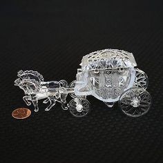 a glass figurine of a horse drawn carriage with a penny on the side