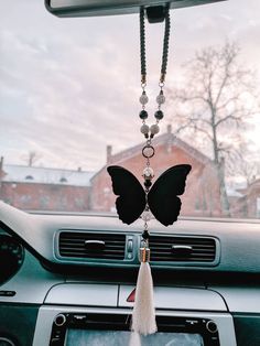 a car dashboard with a butterfly decoration hanging from the dash board