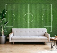 a living room with a couch and soccer field wall mural on the wall behind it