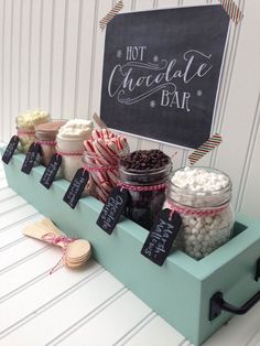 an assortment of desserts are displayed on a table with a chalkboard sign in the background