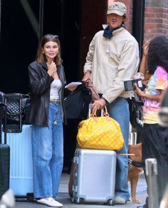 a man standing next to a woman with luggage