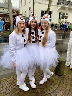 three girls dressed up in costumes posing for the camera