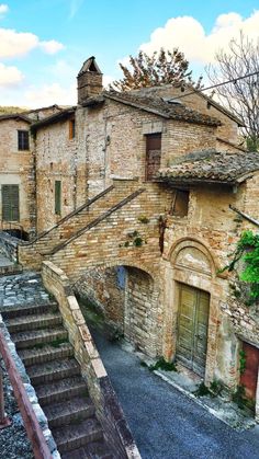 an old stone building with stairs leading up to it