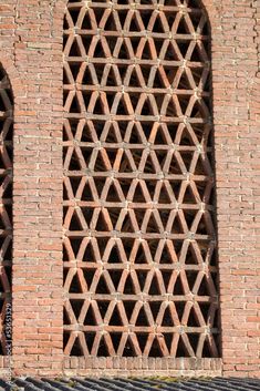 an old brick wall with two windows in it