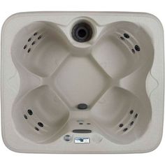 an overhead view of a white hot tub with four holes on the side and three black knobs