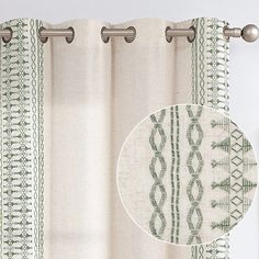 the curtain is hanging in front of a window with an embroidered design on it, along with a round metal rod