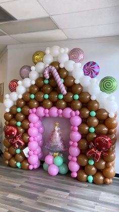 an inflatable gingerbread house with candy canes and balloons on the wall