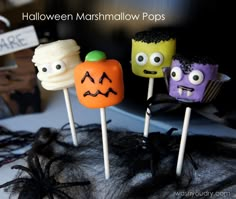 three halloween marshmallow pops with faces on them