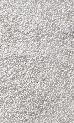 a white wall that has some kind of textured surface on it, with small dots in the middle