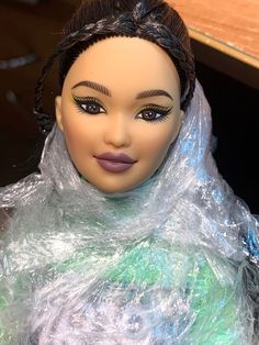 a close up of a doll with plastic wrap around it's head