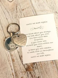 a heart shaped keychain with a note attached to it on a wooden surface