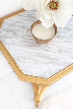 a white flower sitting on top of a marble table